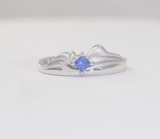Closeup sketch of a men's ring, the M shaped into a mountain range under a starlit sky.