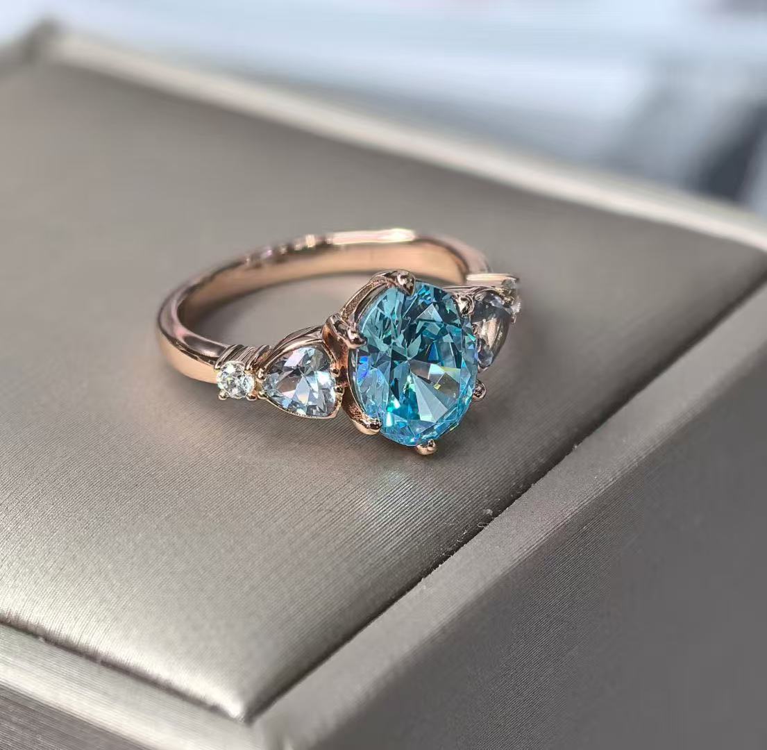 Custom blue gemstone engagement ring in a rose gold setting by FashionHaydee