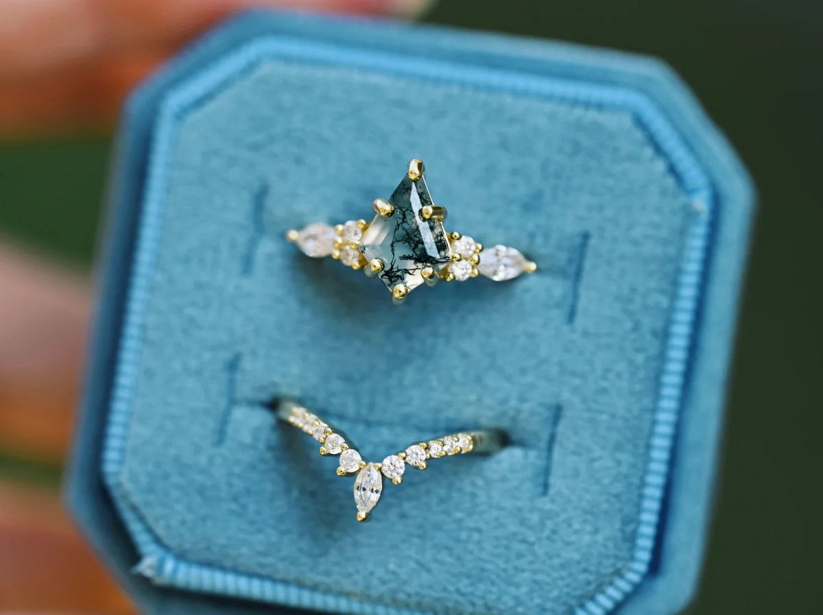 Close-up of a moss agate wedding ring with natural fern inclusions in a gold band.