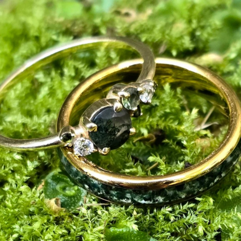 A wedding ring set featuring moss agate and moissanite in matching bands.